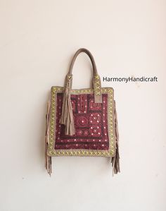 Welcome to HarmonyHandicraftCo Banjara shoulder bag is large enough to hold everything you need throughout your day, Made of antique hand-embroidered Banjara Patch and Leather Thread textiles, with intricate embellishments, bag is truly unique. Size in Inches ( Approx ) Height with handle -25 Height - 16" Width - 15" Sides - 4" Inside Pocket - 3 Outside Pocket - No Closure - Zipper This Bag is made from Leather and hand embroidered Kutchi tribal fabrics which features multi color mirror work, sequins, Beautiful patchwork of colorful hand embroidered work. These multi color cotton shoulder bags are brilliantly embroidered with leather strap. Very colorful and striking color purse, It can be a unique gift for girls, girl friends, sisters, daughters. Housewives, and can a perfect match with a Boho Shoulder Bag, Unique Gifts For Girls, Bohemian Bag, Bag Embroidery, Leather Fringe Bag, Color Mirror, Bohemian Bags, Leather Sling Bag, Embroidery Bags