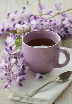 a cup of tea and some purple flowers