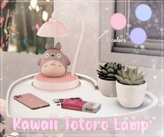 a totoro lamp sitting on top of a table next to a potted plant