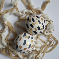 two decorated eggs sitting on top of cotton