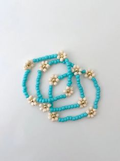 one turquoise seed bead flower bracelet with 14k gold accents made on a durable stretch elastic cord please refer to our sizing guide before you purchase Turquoise Flower Bracelets With Colorful Beads, Turquoise Beaded Flower Bracelet, Turquoise Beaded Flower Bracelets, Handmade Turquoise Flower Beaded Bracelets, Adjustable Turquoise Flower Beaded Bracelet, Seed Bead Flower Bracelet, Bead Flower Bracelet, Seed Bead Flower, Seed Bead Flowers