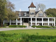 a large white house sitting on top of a lush green field