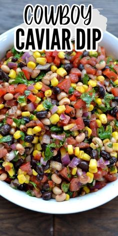 a white bowl filled with black eyed peas, corn and cilantro sauce on top of a wooden table