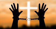 two hands are chained to a cross with chains