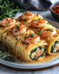 shrimp and spinach wrapped in tortilla shells on a white plate with garnishes