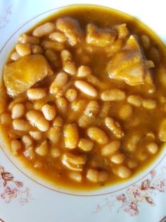 a white plate topped with beans and meat