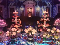 a table topped with lots of cakes and cupcakes on top of glass plates