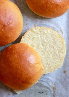 three buns sitting on top of a piece of wax paper