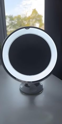 a round light sitting on top of a table next to a window