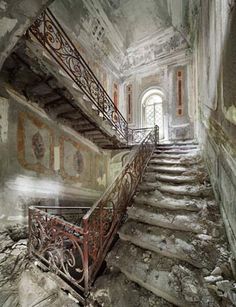 an abandoned building with stairs and paintings on the walls