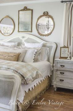 a white bed sitting in a bedroom next to two mirrors