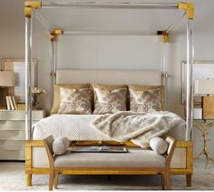 a bedroom with a four poster bed and beige furniture in the corner, along with two lamps on either side of the bed