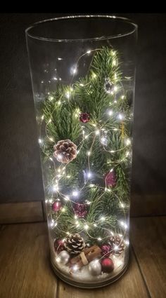 a glass vase filled with christmas decorations and lights