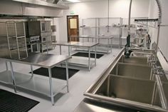 an industrial kitchen with stainless steel appliances and sinks