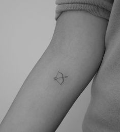 a small bow tattoo on the arm