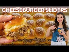 a woman is holding up a cheeseburger slider in front of the camera