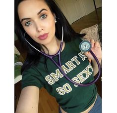 a woman with a stethoscope on her neck is taking a selfie