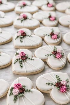 cookies decorated with white icing and pink flowers