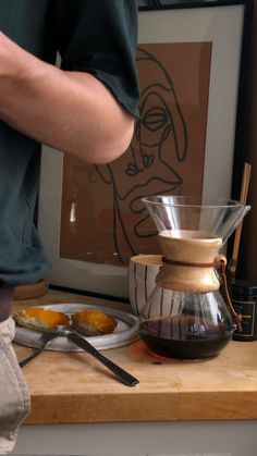 a person pouring coffee into a glass pitcher