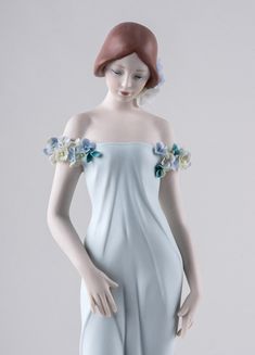 a figurine of a woman in white dress with flowers on her head and arms