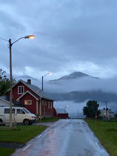 a wet road in front of a red building