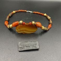 The Beautiful Necklace Of Old Antique Hadid Stone Intaglio Cylinder Seal Stamp Beads A long With Vintage Sulumani Banded Agate and Carnelian Beads Every Bead is Beautifully Carved Into Rare Story Scene Like Ancient Sasanian , Babylon Style As You Can See in The Above Pictures The Beads are Old But The Carving Is Recently Make NEW Carving Same Style Story Scene As Ancient Sasanian ,Babylon Times Some Gold Plated Wax Beads and Some Brass Gold Color Beads are Used As Spacers Fast and Free Shipping Traditional Carnelian Gemstone Beads, Artisan Carnelian Beads For Gifts, Carnelian Amulet Beaded Necklace With Polished Beads, Carnelian Polished Beads Amulet Necklace, Carnelian Amulet Necklace With Large Beads, Traditional Carnelian Oval Beads, Artisan Carnelian Beaded Necklaces, Traditional Carnelian Beads, Traditional Oval Carnelian Beads