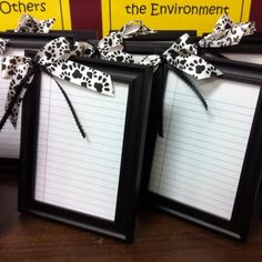 two frames with writing paper tied to them on top of a table next to each other