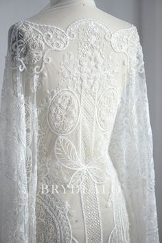 the back of a white wedding dress with long sleeves and laces on it's shoulders