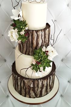 a three tiered cake decorated with flowers and leaves