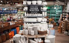 there are many plates and cups on display in the store