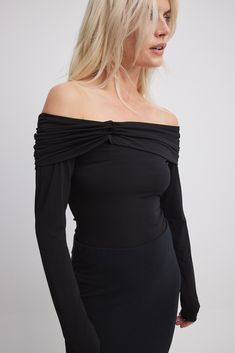 This long sleeve top features a form fit and a slightly sheer stretchy material. It has a folded off shoulder design with a twist detail and a rouched detail at the shoulders. Stretch Off-shoulder Long Sleeve Top For Fall, Stretch Long Sleeve Off-shoulder Top For Fall, Fitted Long Sleeve Off-shoulder Top For Spring, Fitted Black Long Sleeve Off-shoulder Top, Chic Fitted Long Sleeve Off-shoulder Top, Fitted Black Off-shoulder Long Sleeve Top, Chic Fitted Off-shoulder Long Sleeve Top, Fitted Off-shoulder Top For Fall, Chic Fitted Long Sleeve Top With Ruched Details