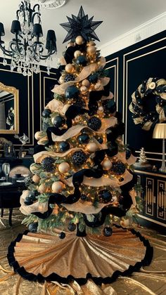 a decorated christmas tree in the middle of a room with black walls and gold trimmings