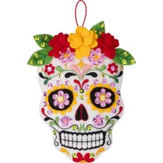 a colorful skull ornament with flowers on it's head, hanging from a string