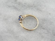 This classic ring is timeless and elegant, a three stone style that has been popular for centuries, and will remain fashionable for years more to come. The beauty of this style of ring is the focus it gives the stones - there's no distracting from their luxurious sparkle! We've set this ring with one of our finest sapphires. Originating in Sri Lanka, we chose this Ceylon Sapphire personally during one of our frequent gem buying trips. The color is perfection, a rich cobalt blue that is considere Formal Trillion Cut Three Stone Jewelry, Classic Formal Sapphire Ring With Trillion Cut, Formal Three Stone Trillion Cut Jewelry, Formal Three-stone Trillion Cut Jewelry, Classic Trillion Cut Sapphire Ring, Elegant Three-stone Birthstone Ring In 14k Gold, Elegant Three Stone Birthstone Ring In 14k Gold, Classic Trillion Cut Sapphire Jewelry, Timeless Three Stone Ring In 14k Gold