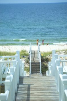 stairs lead down to the beach with people in the water