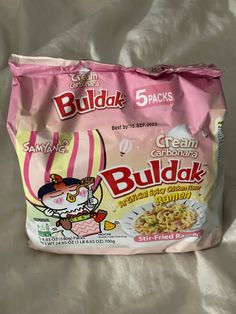 a bag of budak cereal sitting on top of a bed