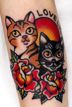 a tattoo with two cats and roses on it