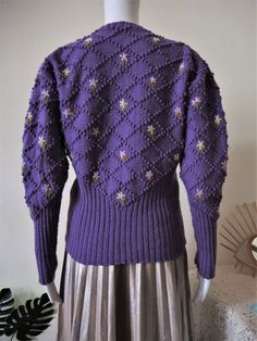 Stunning True Vintage Austrian trachten cardigan from the 1970s. Hand-knit from soft wool fabric in a beautiful dusky purple shade. The tons of bobbles in a luxurious diamond knit pattern and the nostalgic floral embroidery make this cardigan stand out! The lower part is a rib knit which futrher adds to the charme of this nostalgic cardigan. Original Vintage handicraft item from Austria! Looks great combined with a pair of highwaist jeans and a white statement collar. BRAND: No brand label, it's Fitted Purple Knitted Cardigan, Vintage Purple Sweater For Winter, Vintage Purple Winter Sweater, Fitted Vintage Purple Sweater, Vintage Purple Cardigan For Winter, Vintage Purple Winter Cardigan, Purple Vintage Winter Cardigan, Fitted Purple Cardigan With Buttons, Dusky Purple