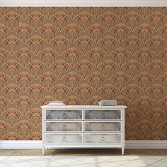 an empty room with a dresser and wallpaper