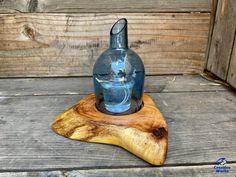 a glass bottle sitting on top of a wooden stand