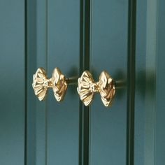 two gold bow handles on a green door