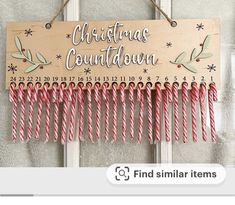 a wooden sign hanging from the side of a door that says christmas count down with candy canes