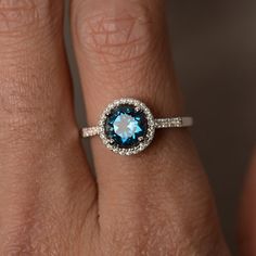 This is a gorgeous handmade creation. Its beauty is its simplicity & Elegance. The 7*7mm round cut London blue topaz is crafted in solid sterling silver and with rhodium plated. All item is sent in a beautiful gift box!!! You can realize more lovely stuff clicking the link Hallmarked Blue Topaz Ring In Round Cut, Blue Topaz Halo Ring As Gift, Blue Topaz Ring With Halo Setting In Sterling Silver, London Blue Topaz Halo Ring, Silver Blue Topaz Ring, Round Cut, Blue Topaz Engagement Ring, Topaz Engagement Ring, London Blue Topaz Ring, Birthstone