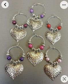 six wine charms with hearts and beads on them