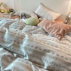 an unmade bed with pillows and blankets on it