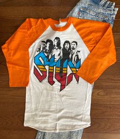 1978 Styx Raglan The colors of this raglan with the bands faces are just incredible. I love the feel of this raglan with the white and orange sleeves This raglan is sold as is due to the staining on the tee. For any STYX lover it is a small detail though. I have not attempted to remove these stains and you may be able to. PLEASE SEE PICTURES AND MESSAGE ME IF YOU HAVE ANY QUESTIONS Tag reads - Medium Width - 16 inches Length - 27 inches White And Orange, Concert Tees, Halloween Tees, Small Detail, Favorite Shirts, Vintage Tshirts, Raglan Sleeve, Cool Shirts, The White