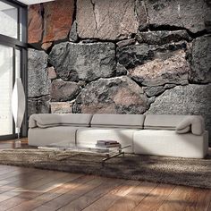 a living room with stone walls and wooden floors