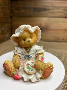 a small teddy bear sitting on top of a white plate