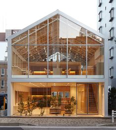 a large glass building with stairs leading up to it's second floor and windows