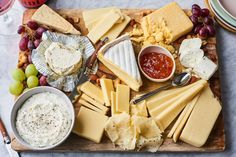 cheese, crackers and grapes on a wooden board